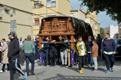 Los costaleros realizando los ensayos con el paso por las calles del barrio, acompañados por decenas de vecinos y cofrades.