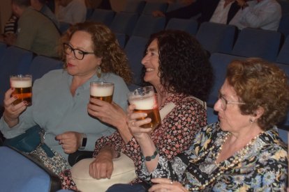 Tres de las asistentes al acto, degustando la cerveza en un vaso cañón.