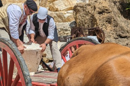 Los canteros a base de rulos colocan los bloques en el carro.