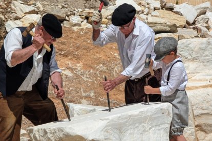 Los canteros zoblan un bloque de mármol.