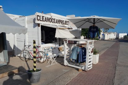 Caseta de \'Clean Ocean Project\' en La Isleta del Moro, en la que venden camisetas y sudaderas  cuyas ganancias se destinan a la organización de actividades medioambientales.