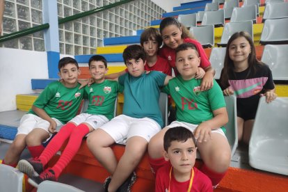 Los niños y las niñas esperan en la grada para participar en un torneo muy emotivo. 