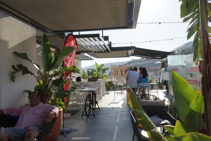 El ático tiene una parte de sofás y una parte de mesas altas.