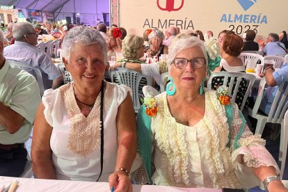 Amor Cruz se hace todos los años varios vestidos a mano para disfrutar de la Feria. En la foto posa junto a su amiga Guadalupe Úbeda.