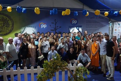 Jóvenes del Partido Popular posan junto a Javier Aureliano García en la puerta de la caseta del PP.