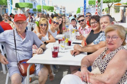 La familia de los relojeros-carpinteros toman unos refrescos con su respectiva tapa en la feria.