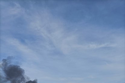 El fuego en el camión ha levantado una densa nube de humo negro.