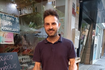 Ismael, en la puerta de su popular frutería en Plaza San Pedro posando con un cesto lleno de castañas. 