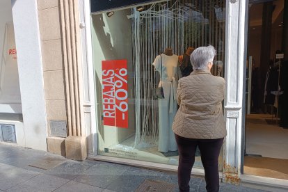 Una mujer mirando el escaparate de una de las tiendas con rebajas en el Paseo de Almería.