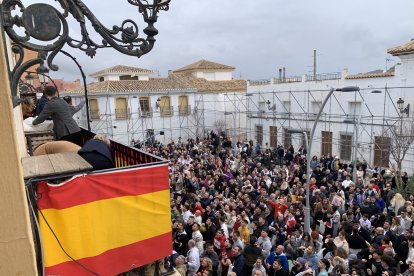 Los asistentes cogen los roscos que se lanzan desde el ayuntamiento.