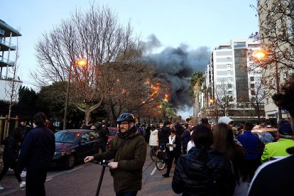 Decenas de personas observan el edificio en llamas.