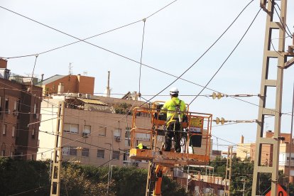 Un empleado corta el hilo de la catenaria.