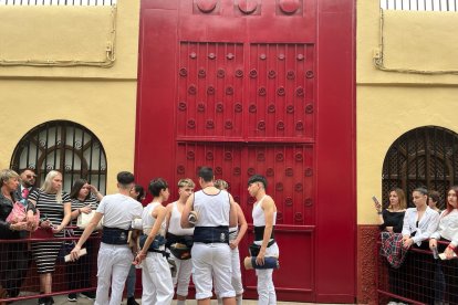 Varios costaleros congregados a las puertas de la Parroquia de San Isidro minutos antes de que se abrieran sus puertas.
