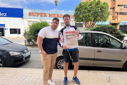 Un redactor de LA VOZ entrega un periódico y un clavel a Alejandro.