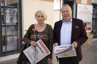 Pedro Manuel de la Cruz entrega un periódico y un clavel a Marisa Martínez, ama de casa.