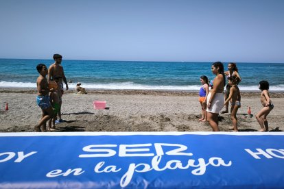 Animadores de Decroly Kids junto a los niños jugando a pie de playa.
