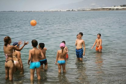 Equipo de Decroly Kids y los peques jugando en la playa a la pelota.