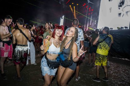 Dos amigas posan con el abanico oficial del festival para aliviar el calor.