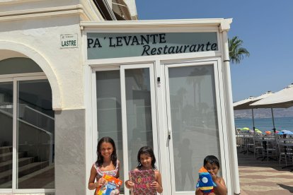 Mía, Julia y José felices con sus regalos de papelería Carlin y ToyPlanet, delante del restaurante PA’LEVANTE.