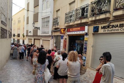 Cola para el reparto de abanicos en la Plaza Vieja.