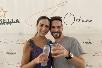 Ángela y Juan, pareja malagueña brindando con un rostro feliz ante el photocall de Ibéricos Ortuño.