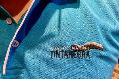 Logo del local situado en la zona superior derecha del uniforme de trabajo.