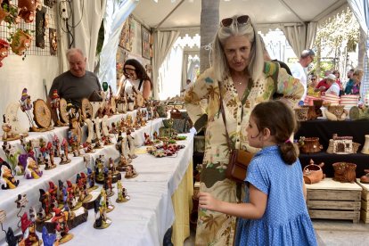 Dos personas observan las piezas de Javi Artesanía Creativa, en la feria de alfarería de Almería.
