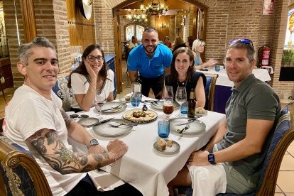 Cristóbal Correro junto a una mesa de comensales formada por