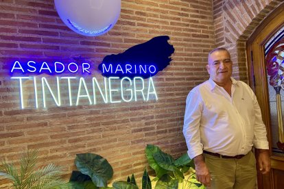 José Garrido, uno de los comensales, residente en La Venta de Pobre, posando en la entrada del local junto al cartel de Asador Marino.
