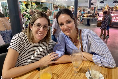 Rocío y Elena, amigas desayunando mientras sus hijas están el el taller de cocina. 