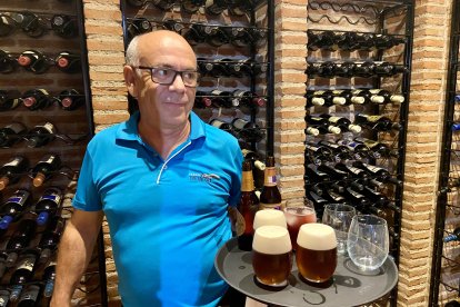 Paco, uno de los camareros de feria sosteniendo la bandeja con cerveza y tinto para servir a los comensales.