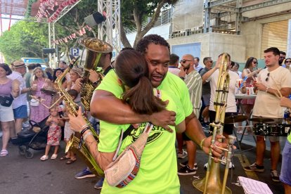 Dos músicos de una de las charangas del centro se abrazan en el ambigú de la Hermandad de la Estrella.