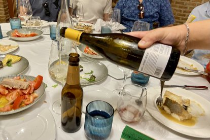 Imagen de uno de los camareros sirviendo una copa de vino blanco.