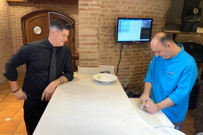 J. L. Bernabé observando a José Manuel Berenguer limpiar las ostras.