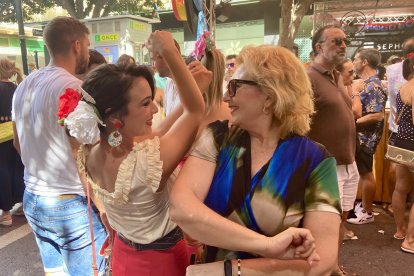 Belén y Lola, madre e hija de Almería, bailan al ritmo de la música del ambigú de la Hermandad de la Estrella.