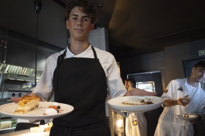 El cocinero Mariano Gómez con dos platos recién preparados.