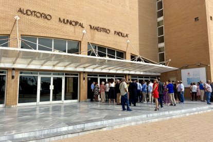 Asistentes se agrupan a las puertas del auditorio.