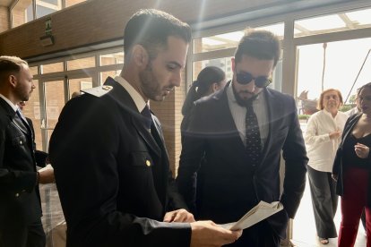 El acomodador señala su asiento a un asistente.