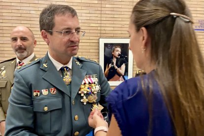 Una asistente admira las medallas de un agente.