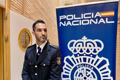 Un agente de la Policía Nacional controla el acceso a la sala donde ha tenido lugar el acto.