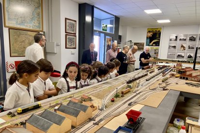 Alumnos contemplan asombrados la salida de los trenes de la pequeña estación recreada en la maqueta.