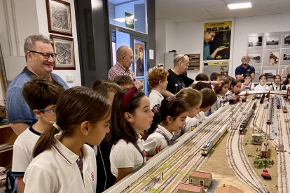 Alumnos contemplan asombrados la salida de los trenes de la pequeña estación recreada en la maqueta.