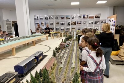 Alumnos contemplan asombrados la salida de los trenes de la pequeña estación recreada en la maqueta.