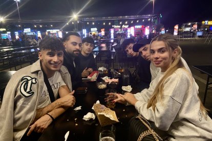 Varios amigos de toda la vida procedentes de Retamar comen las hamburguesas del evento.