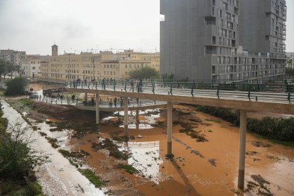 Varias personas observan los estragos causados por la DANA en un barrio de Valencia.