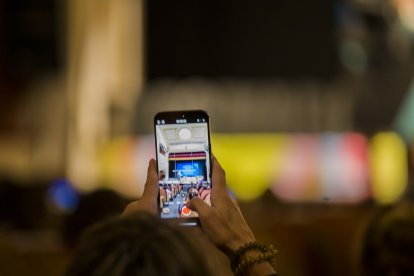 Una persona del público echa una foto del espectáculo.