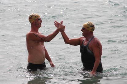 Funcia y PLaza, segundo y tercero de la Golden, chocan la mano al salir del agua.
