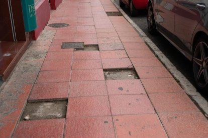 Losas de una acera rotas y levantadas.