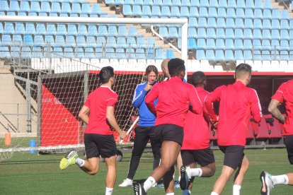 El entrenador habla con su ayudante mientras el equipo entrena.