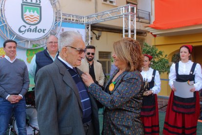 La alcaldesa de Gádor le impone la insignia de oro al homenajeado.